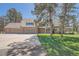 Charming two-story home with a manicured front lawn, a three-car garage, and mature trees at 38666 County Road 21, Elizabeth, CO 80107