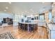 Open-concept kitchen with island seating, wood floors, white cabinetry, and stainless appliances at 38666 County Road 21, Elizabeth, CO 80107