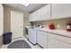 Bright laundry room featuring a washer, dryer, storage cabinets, and white countertops at 38666 County Road 21, Elizabeth, CO 80107