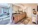 Elegant main bathroom with double sinks, granite countertops, tile flooring, and views of the bedroom at 38666 County Road 21, Elizabeth, CO 80107