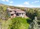 An aerial view of this sprawling estate with a large lawn, outdoor living, and mature evergreens at 6634 Window Rock Ln, Morrison, CO 80465