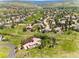 Expansive aerial view of a community nestled within lush green landscapes and a serene lake at 6634 Window Rock Ln, Morrison, CO 80465