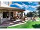 Spacious backyard patio with stone features, comfortable seating, and an outdoor grill, perfect for entertaining at 6634 Window Rock Ln, Morrison, CO 80465