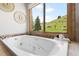 This bathroom features a soaking tub with large windows offering stunning views of the surrounding landscape at 6634 Window Rock Ln, Morrison, CO 80465