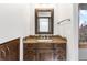 Rustic bathroom featuring wood vanity with stone detail, framed mirror, and wood accents at 6634 Window Rock Ln, Morrison, CO 80465