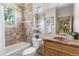 Cozy bathroom featuring tiled walls, a shower-tub combo, and a wooden vanity at 6634 Window Rock Ln, Morrison, CO 80465
