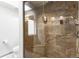 Tiled walk-in shower with glass door features a built-in seat and modern shower fixtures at 6634 Window Rock Ln, Morrison, CO 80465