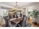 Open concept dining room with stylish light fixture and views to the front entry at 6634 Window Rock Ln, Morrison, CO 80465