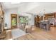 Open floor plan with breakfast nook, kitchen island, and stone fireplace with wood floors at 6634 Window Rock Ln, Morrison, CO 80465