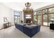 Living room with large windows, stone fireplace, a antler chandelier, and plush sectional at 6634 Window Rock Ln, Morrison, CO 80465
