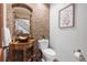 Stylish powder room with unique stone wall, vessel sink, and decorative mirror at 6634 Window Rock Ln, Morrison, CO 80465