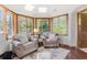 Sunlit sitting area with comfortable armchairs, large windows, and scenic views at 6634 Window Rock Ln, Morrison, CO 80465