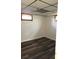 Basement area featuring a drop ceiling, a small window and modern wood-look flooring at 609 S 1St Ave, Brighton, CO 80601