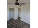 A bright room featuring a ceiling fan, an open closet door and modern wood-look flooring at 609 S 1St Ave, Brighton, CO 80601