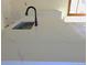 Close-up of a quartz countertop with a sleek black sink and faucet at 609 S 1St Ave, Brighton, CO 80601