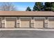 Row of attached garages with decorative brick accents under a blue sky at 4084 S Crystal Cir # 104, Aurora, CO 80014
