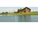 A charming view of a community building next to a serene pond with lush landscaping at 10185 Xanadu St, Commerce City, CO 80022