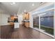 Modern kitchen features wood cabinets, black appliances, and a center island, opening to the backyard through sliding glass doors at 10185 Xanadu St, Commerce City, CO 80022