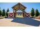 The pavilion is a rustic red structure with white cross beams located inside a lush green Reunion neighborhood at 10185 Xanadu St, Commerce City, CO 80022