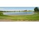 Scenic pond at Reunion with green grass and blue skies, with a barn-style building in background at 10185 Xanadu St, Commerce City, CO 80022