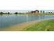 Waterfront view of pond at Reunion with a barn in background and green grass on banks at 10185 Xanadu St, Commerce City, CO 80022