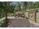 Outdoor patio area with gravel, green accent walls, and natural shade trees at 20410 Brookmont Rd, Morrison, CO 80465