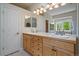 Bright bathroom with a long vanity, double sinks, and wooden cabinets at 20410 Brookmont Rd, Morrison, CO 80465