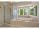 Bright bathroom featuring a soaking tub with a view and a glass shower at 20410 Brookmont Rd, Morrison, CO 80465