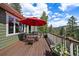 View of wooden deck featuring mountain views, a red umbrella, and outdoor furniture at 20410 Brookmont Rd, Morrison, CO 80465