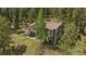 Two-story home with a deck and lush green landscaping on a mountainside at 20410 Brookmont Rd, Morrison, CO 80465