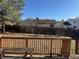 Back yard view from deck of fenced yard with grass, trees, and adjacent homes at 1719 S Ensenada Way, Aurora, CO 80017
