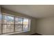 This bedroom features neutral walls, carpet, and a large window providing natural light at 1719 S Ensenada Way, Aurora, CO 80017