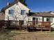 Rear elevation view of home with wood deck, windows, and fenced back yard at 1719 S Ensenada Way, Aurora, CO 80017