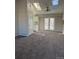 Bright living room with skylights, neutral walls, ceiling fan and doors to outdoor patio at 1719 S Ensenada Way, Aurora, CO 80017