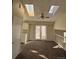 Bright living room with skylights, neutral walls, ceiling fan and doors to outdoor patio at 1719 S Ensenada Way, Aurora, CO 80017
