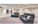 Basement media area with carpeting, two black leather reclining couches and mountain artwork at 3525 Rinn Valley Dr, Longmont, CO 80504