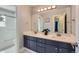 Bathroom featuring double sinks, large mirror, and view of shower and toilet at 3525 Rinn Valley Dr, Longmont, CO 80504