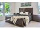 Comfortable bedroom featuring a large window and a wood-framed bed with throw blanket at 3525 Rinn Valley Dr, Longmont, CO 80504