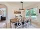 Bright dining room with rustic wood table, white chairs, and modern light fixture at 3525 Rinn Valley Dr, Longmont, CO 80504