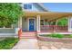 Inviting home front entrance with a covered porch and blue door at 3525 Rinn Valley Dr, Longmont, CO 80504