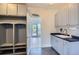 Mudroom featuring cubbies with hooks, grey cabinetry and a utility sink at 3525 Rinn Valley Dr, Longmont, CO 80504