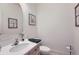 Powder room with a white sink, toilet and framed floral wall art at 3525 Rinn Valley Dr, Longmont, CO 80504