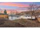 Exterior of home with brick and wood fence, and backyard featuring mountain views at 214 Iowa Dr, Golden, CO 80403