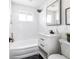 Bathroom with tub and shower, white vanity with black hardware, and dark hexagon tile floor at 214 Iowa Dr, Golden, CO 80403