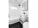 Bathroom with tub and shower, white vanity with black hardware, and dark hexagon tile floor at 214 Iowa Dr, Golden, CO 80403