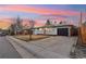 Inviting single-Gathering home featuring a driveway leading to a garage, a front lawn, and a tidy landscape at 214 Iowa Dr, Golden, CO 80403