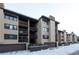 Tan multi-unit building with balconies and garages; winter scene at 246 Broken Lance Dr # 503, Breckenridge, CO 80424