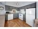 Efficient kitchen featuring gray cabinets, white appliances, and wood-look floors at 246 Broken Lance Dr # 503, Breckenridge, CO 80424