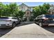 View of the home exterior featuring manicured landscaping, stone accents, and two parked cars at 474 Black Feather Loop # 406, Castle Rock, CO 80104