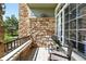 Charming porch features stone accents, comfortable seating, and a view of the community's well-manicured landscape at 474 Black Feather Loop # 406, Castle Rock, CO 80104